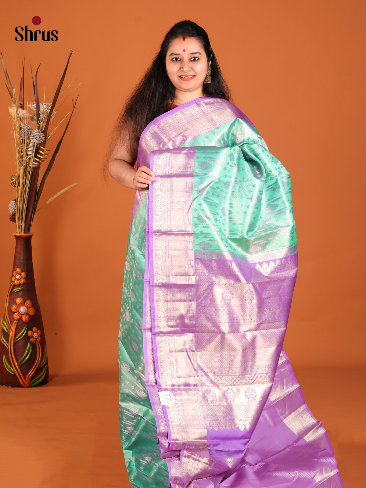 Pista Green & Purple Kanchipuram silk saree gleams with zari floral buttas