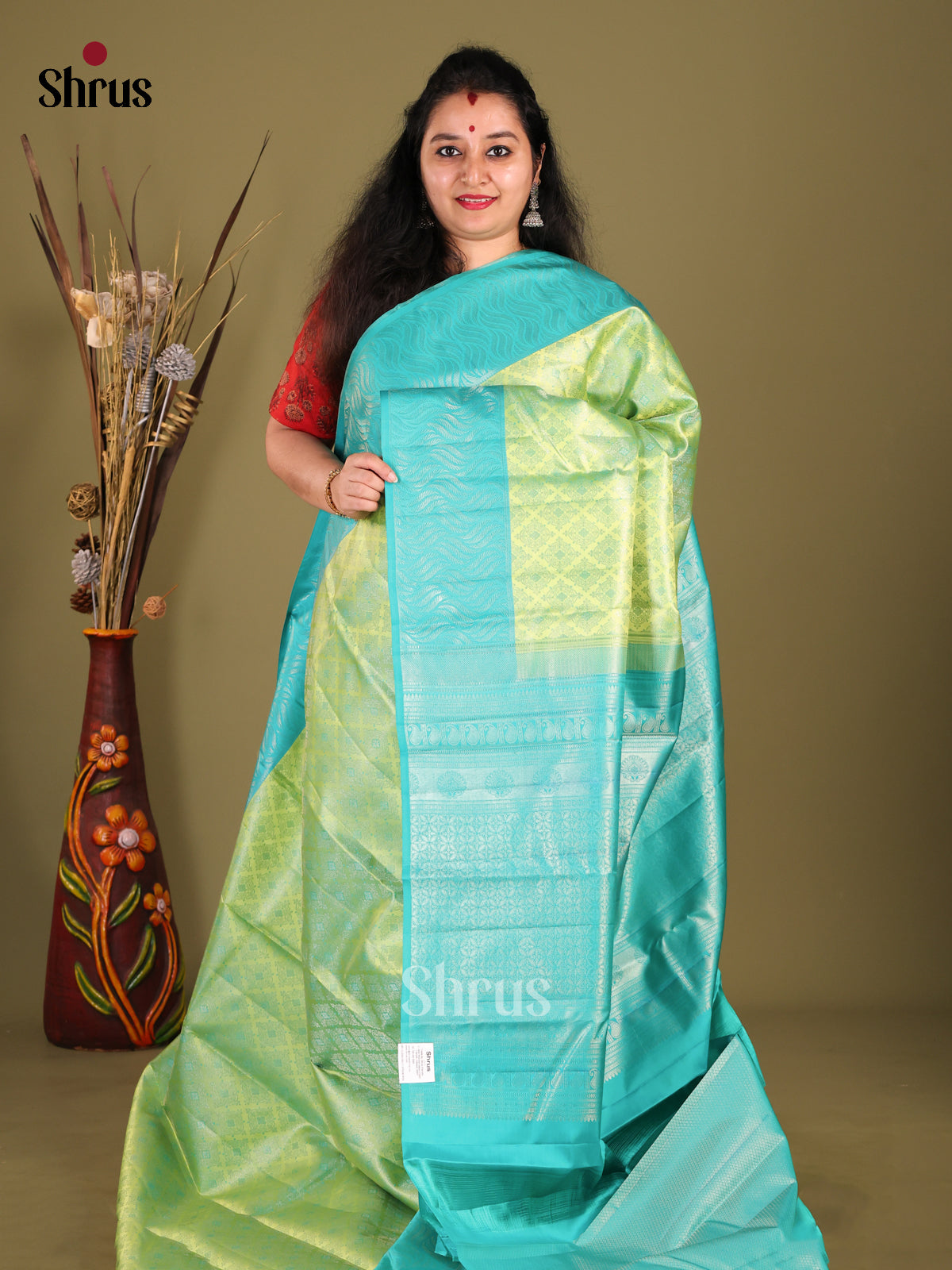 Breezy Light Green Kanjivaram silk Saree with floral nestling brocade & Blue Border