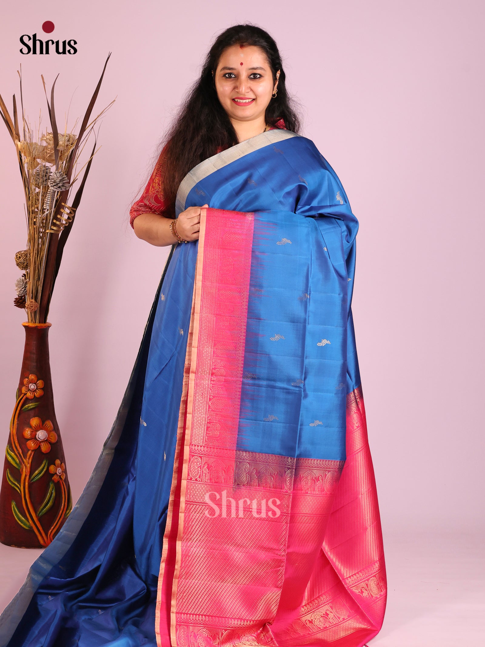 Vibrant blue Soft Silk Saree gleams with zari peacock buttas