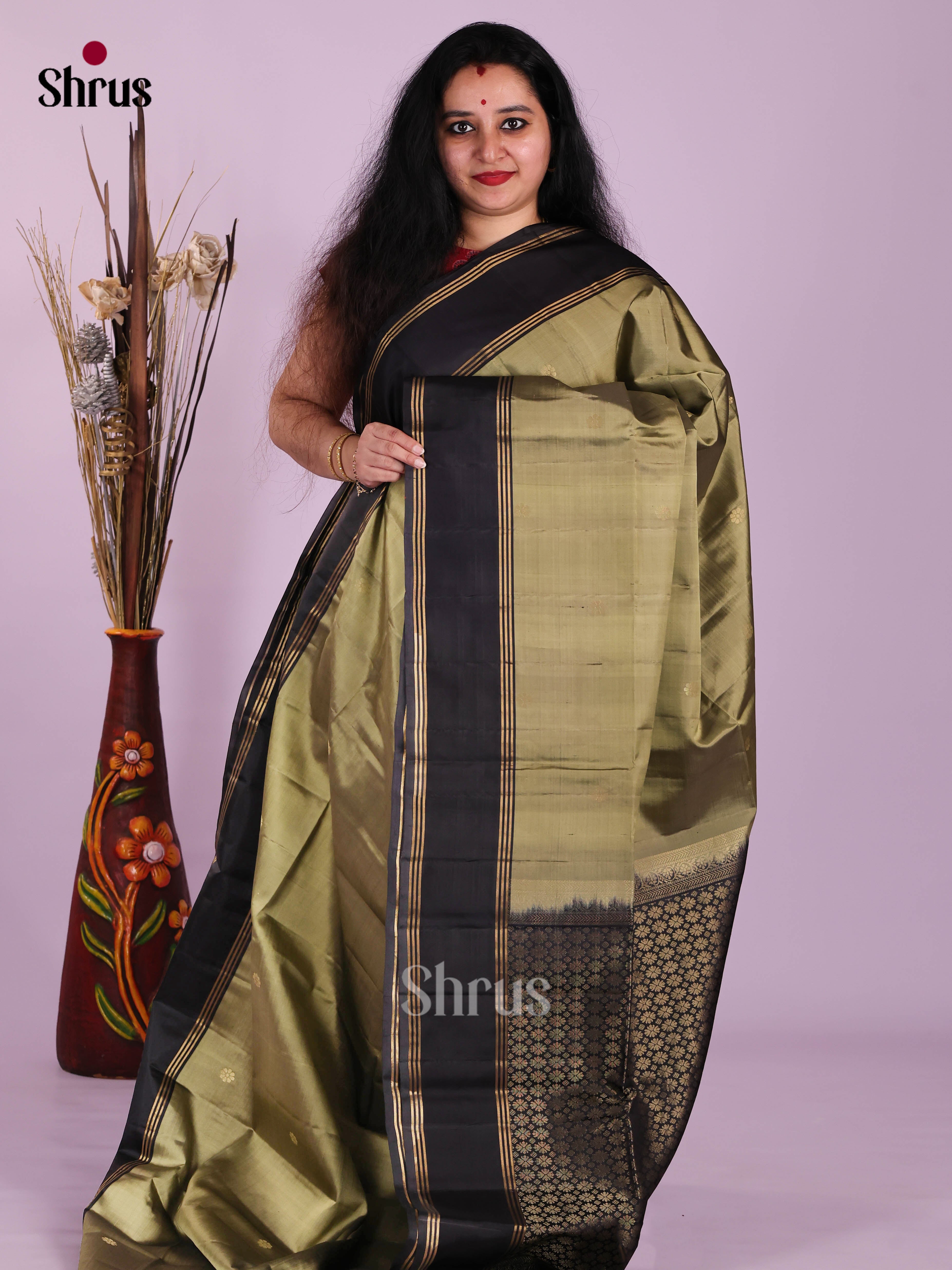 Glimmering Chutney Green & Black Soft Silk Saree gleams with zari floral buttas , rettaipet border