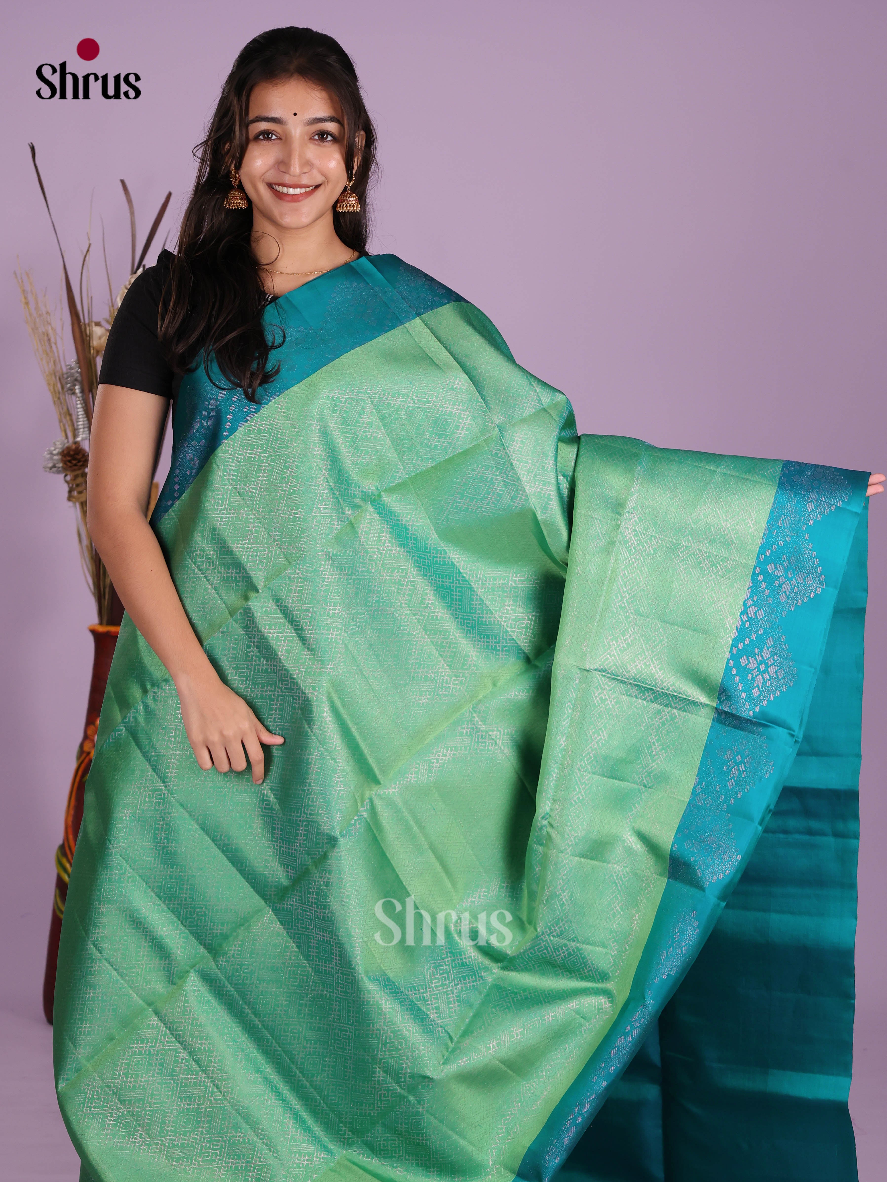 Lustrous Pista green Soft Silk Saree gleams with zari woven floral nestling brocade