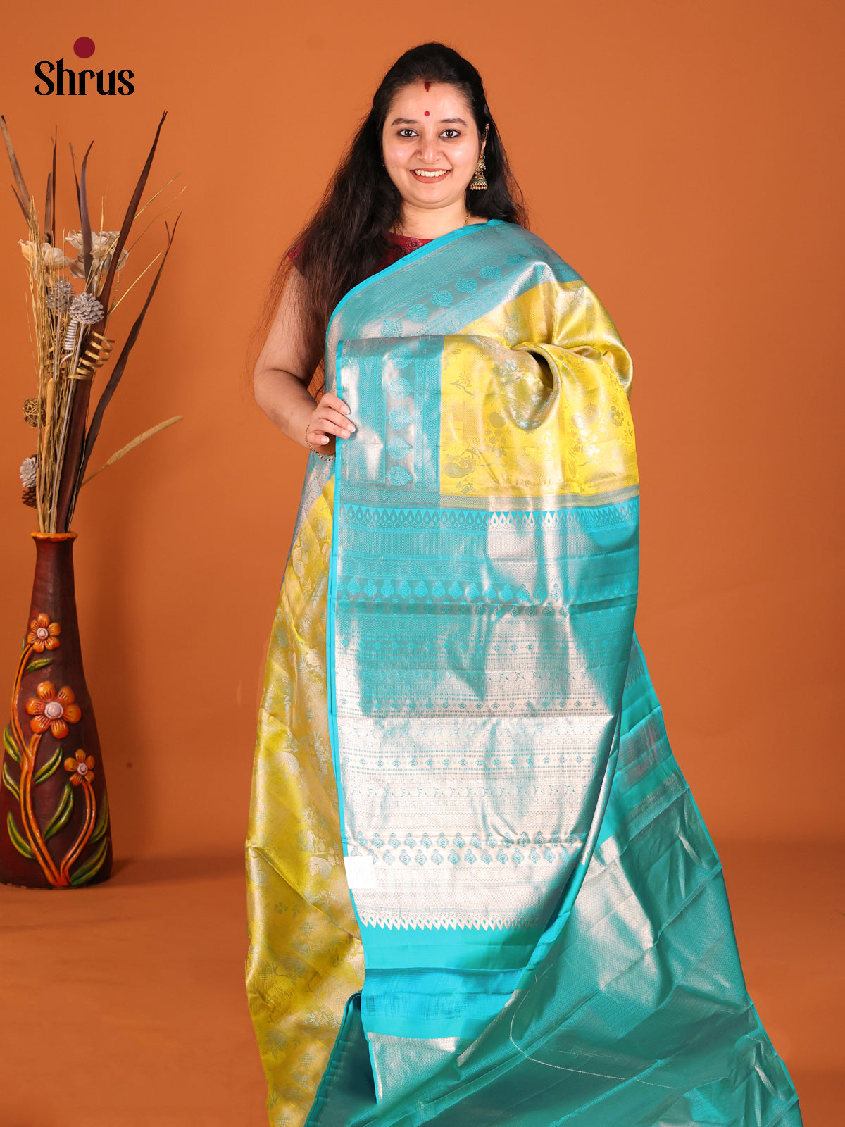 Yellow & Teal Kanchipuram silk saree dazzles with floral nestling brocade
