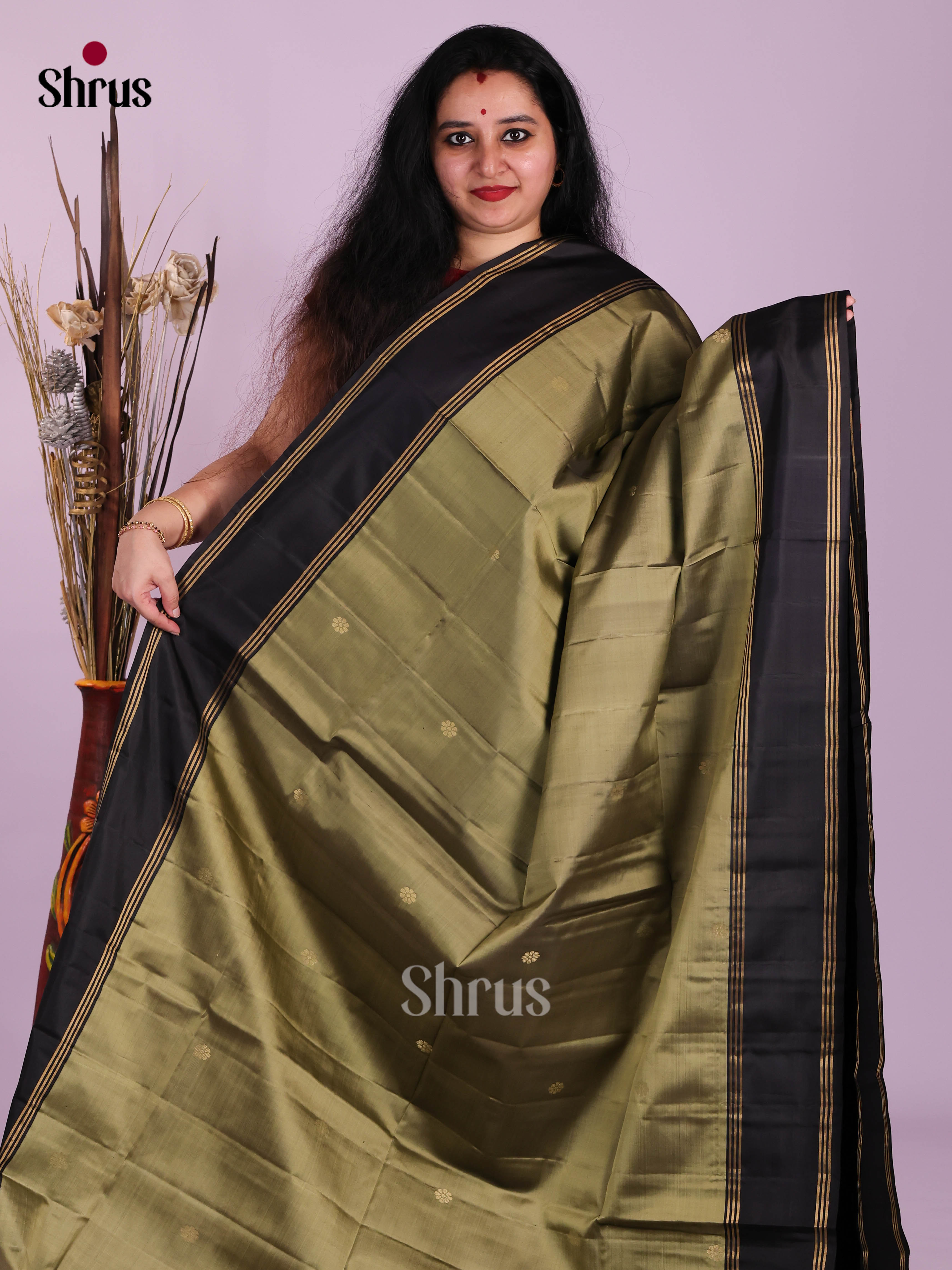Glimmering Chutney Green & Black Soft Silk Saree gleams with zari floral buttas  , rettaipet border