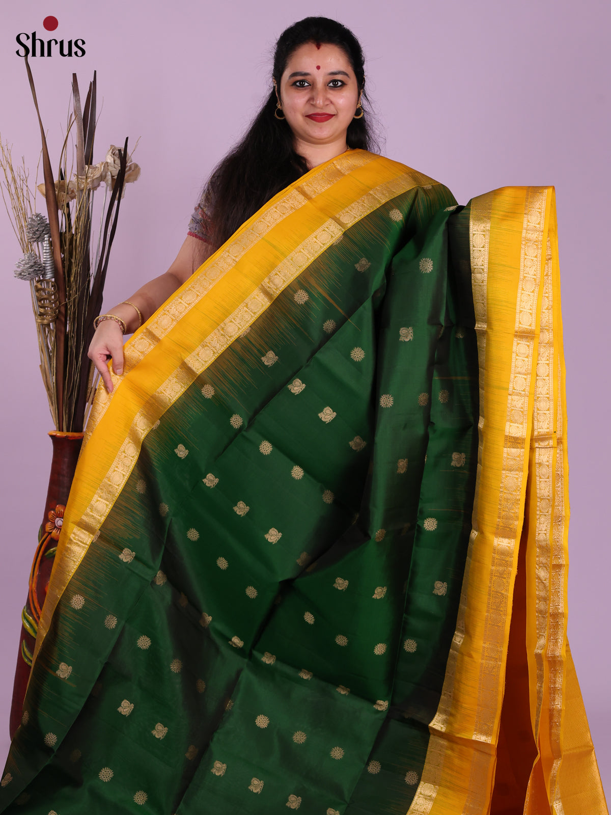 Contemporary Green & Yellow Soft Silk Saree gleams with gold zari peacock buttas