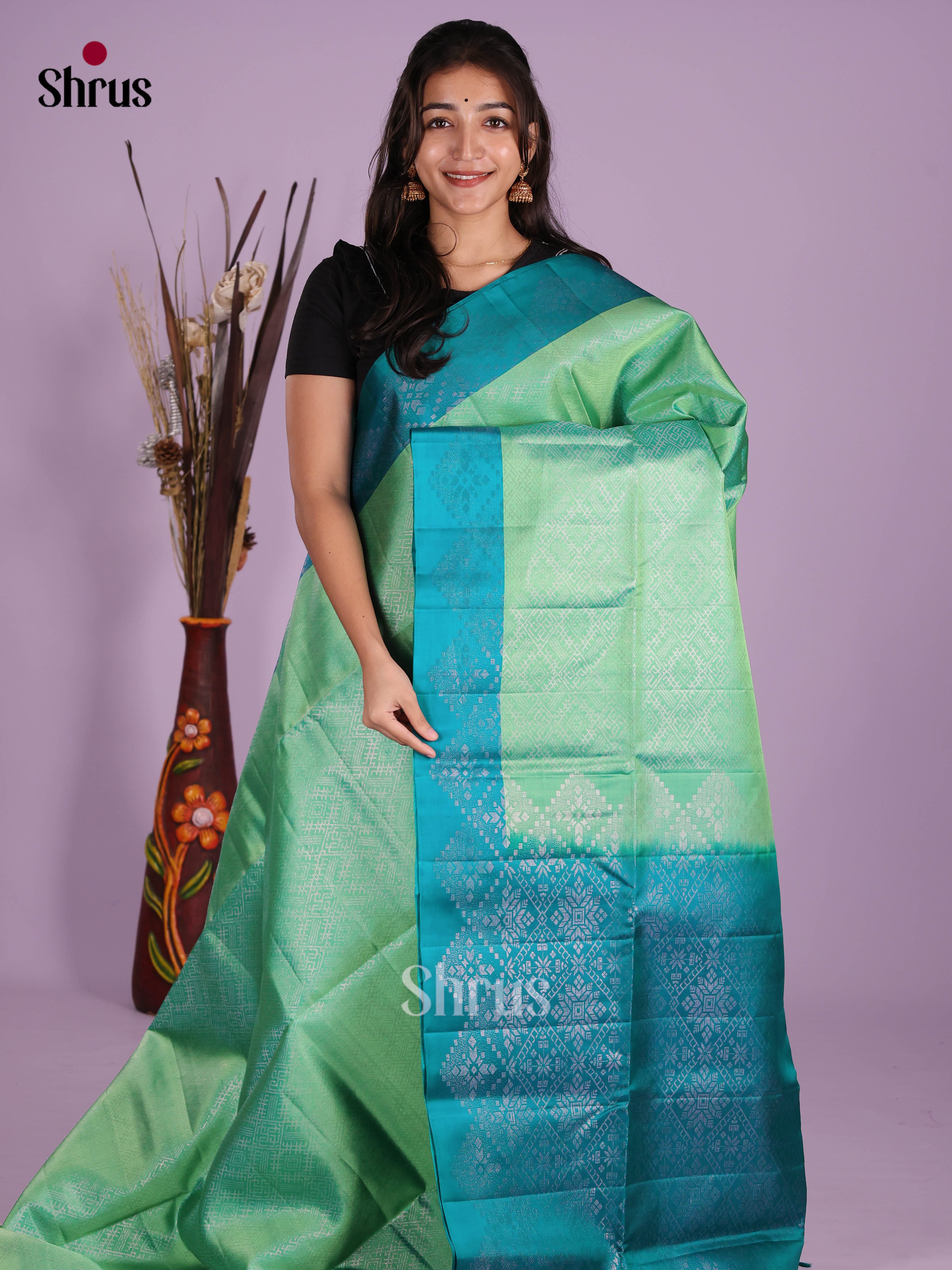 Lustrous Pista green Soft Silk Saree gleams with zari woven floral nestling brocade
