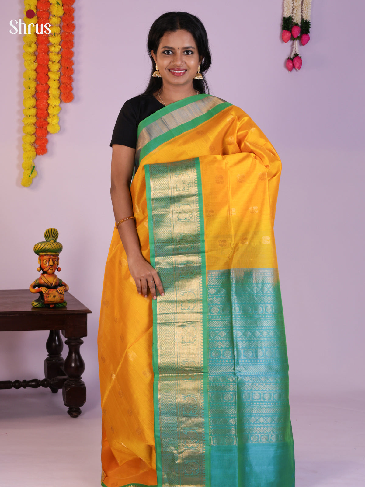 Lustrous Yellow & Teal green Silk Cotton saree gleams with zari peacock buttas - DLS29003